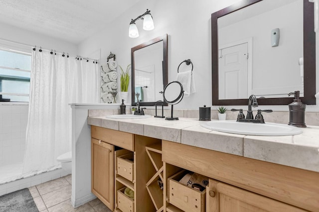 bathroom featuring toilet, tile patterned floors, a shower with curtain, vanity, and a textured ceiling