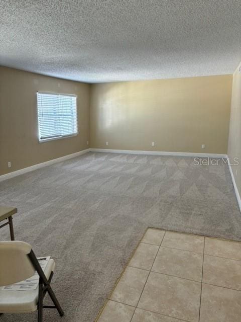 carpeted spare room with a textured ceiling