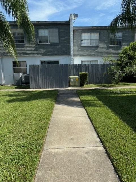 view of front of home with central air condition unit and a front yard