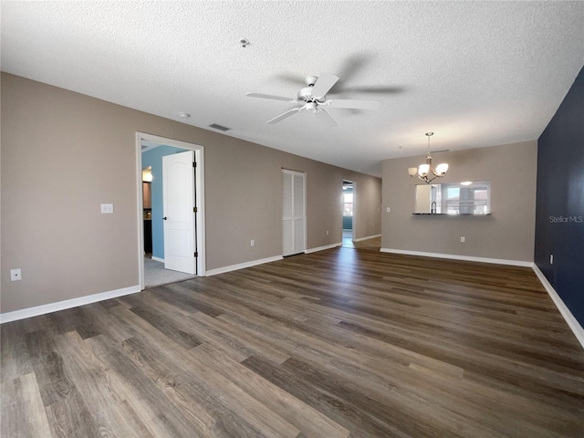 unfurnished room with dark hardwood / wood-style floors, a textured ceiling, and ceiling fan with notable chandelier