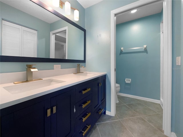 bathroom with tile patterned flooring, vanity, and toilet