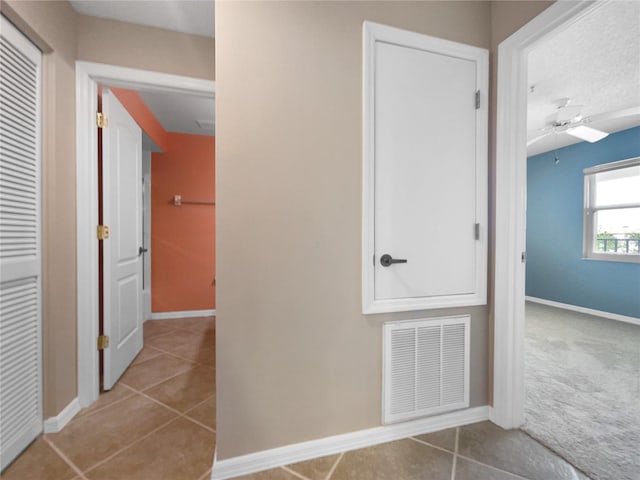 hall with light tile patterned floors