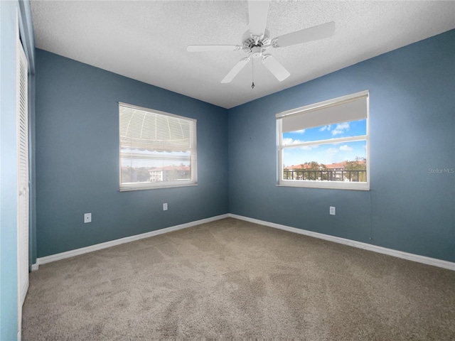 carpeted empty room with a textured ceiling and ceiling fan