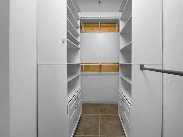 walk in closet featuring dark tile patterned floors