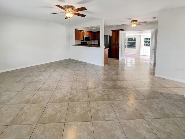 unfurnished living room with ceiling fan