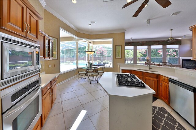 kitchen featuring sink, a center island, decorative light fixtures, light tile patterned flooring, and appliances with stainless steel finishes