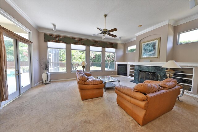 carpeted living room with a premium fireplace, crown molding, ceiling fan, and french doors