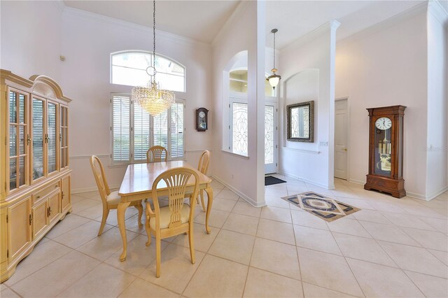 dining area with light tile patterned floors, an inviting chandelier, ornamental molding, and a high ceiling