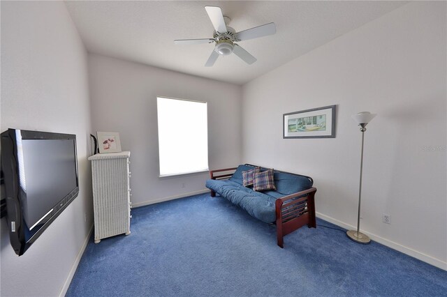 living area with ceiling fan and dark carpet