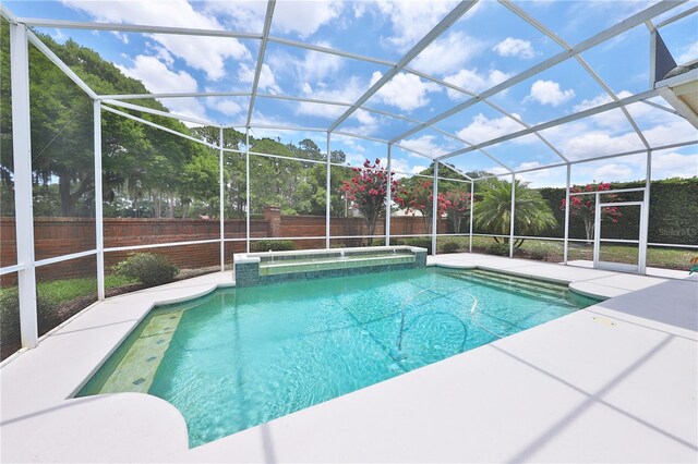 view of pool featuring glass enclosure and a patio area