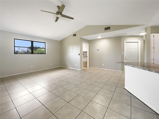 tiled empty room featuring ceiling fan and lofted ceiling