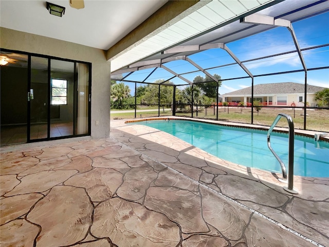 view of swimming pool featuring glass enclosure and a patio area