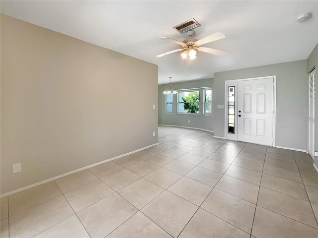 tiled foyer with ceiling fan with notable chandelier