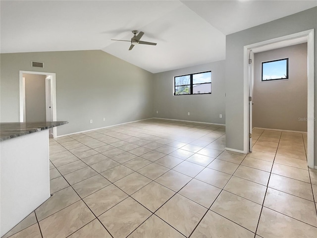 unfurnished living room featuring light tile patterned floors, vaulted ceiling, and ceiling fan