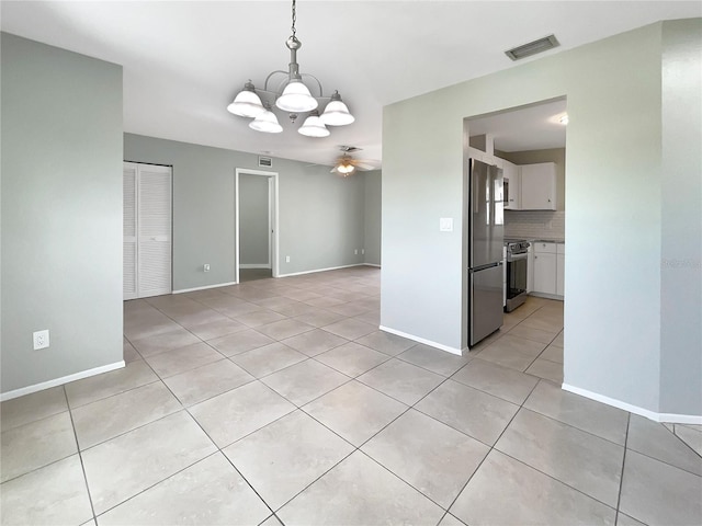 unfurnished dining area featuring light tile patterned floors and ceiling fan with notable chandelier