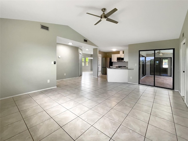 unfurnished living room featuring light tile patterned floors, a wealth of natural light, and vaulted ceiling