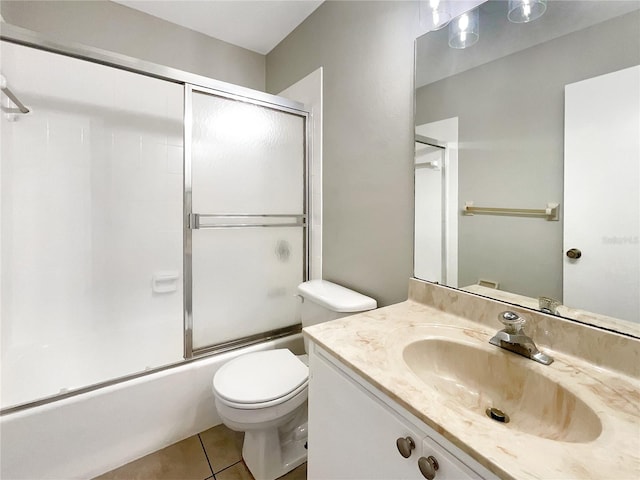 full bathroom with shower / bath combination with glass door, tile patterned flooring, vanity, and toilet