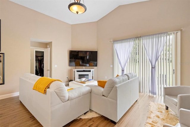 living room with light hardwood / wood-style floors and lofted ceiling