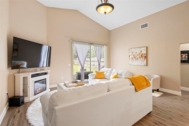 living room with wood-type flooring and high vaulted ceiling