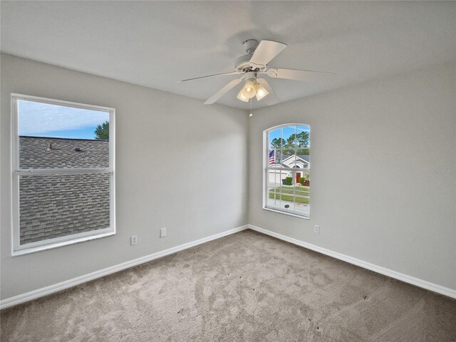 unfurnished room with carpet, ceiling fan, and a healthy amount of sunlight