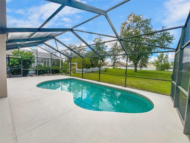 view of swimming pool with a lanai, a yard, and a patio