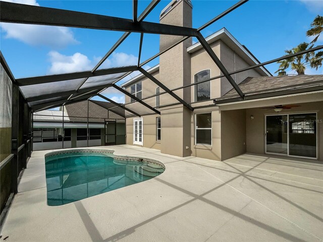 view of pool with french doors, glass enclosure, ceiling fan, and a patio area