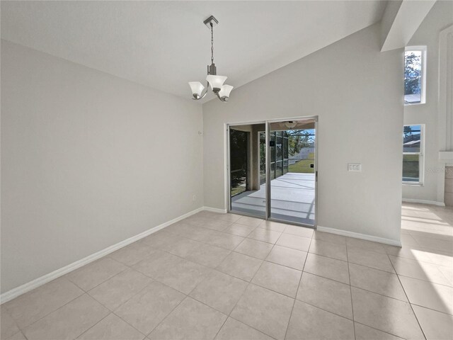 unfurnished dining area featuring vaulted ceiling, light tile patterned floors, and a chandelier