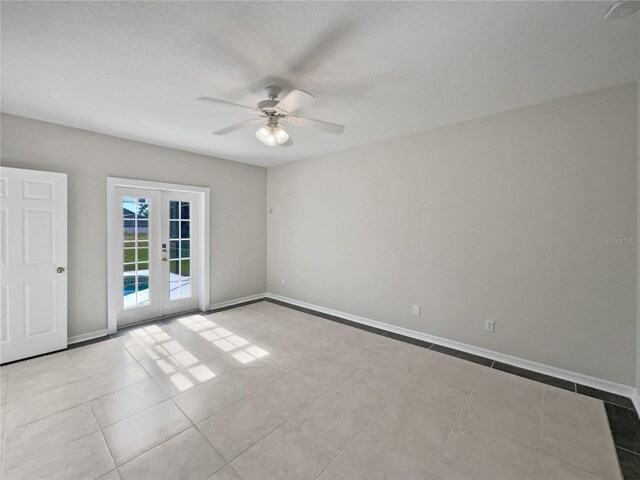 unfurnished room featuring ceiling fan, french doors, and light tile patterned floors