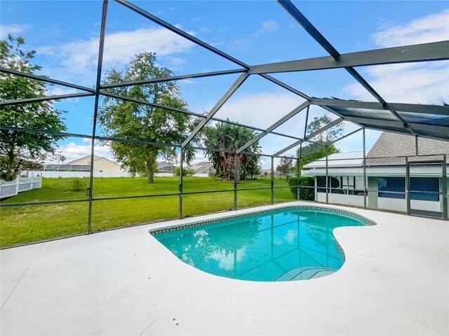 view of swimming pool with a yard, a patio, and glass enclosure