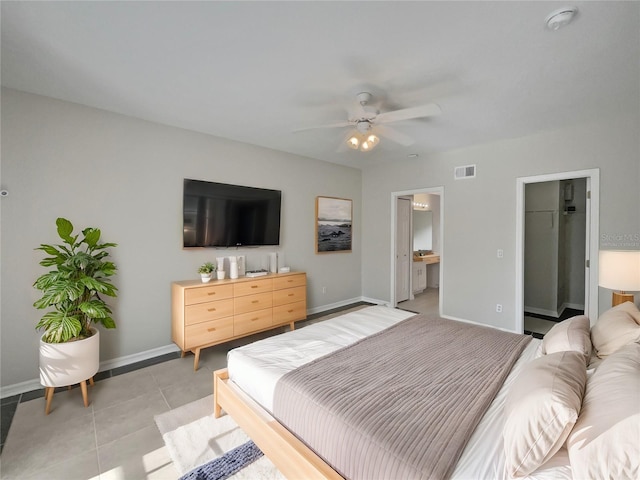 tiled bedroom with ceiling fan, a spacious closet, connected bathroom, and a closet