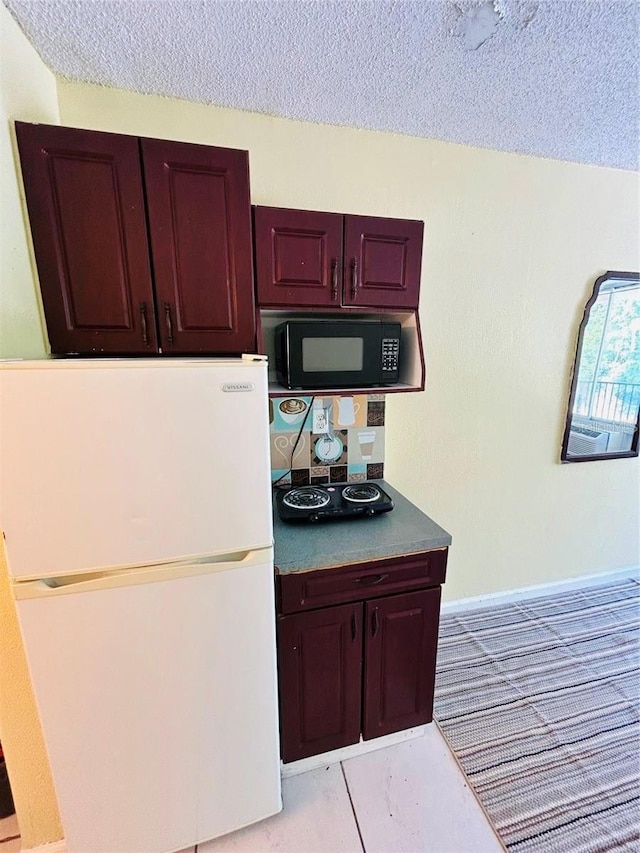 kitchen featuring a textured ceiling and white fridge