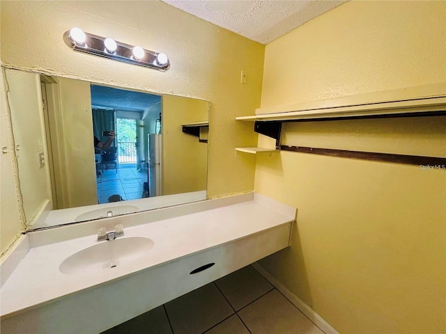 bathroom with tile patterned floors, sink, and a textured ceiling