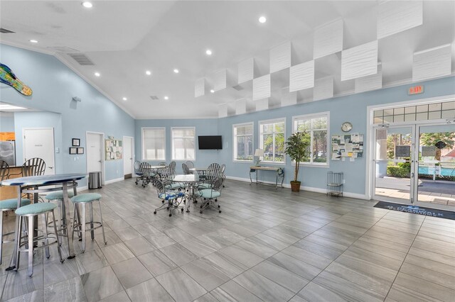 dining space featuring crown molding and high vaulted ceiling