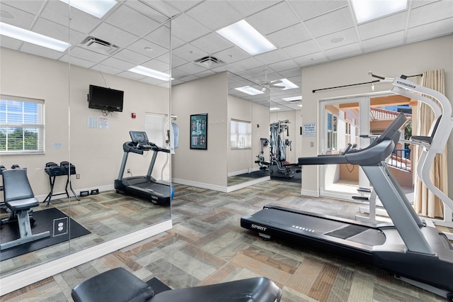 workout area featuring a drop ceiling, carpet floors, and plenty of natural light