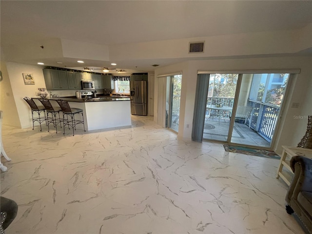 kitchen with a breakfast bar area, stainless steel appliances, and kitchen peninsula