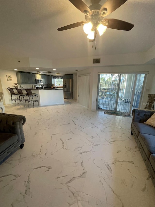 unfurnished living room with a healthy amount of sunlight and ceiling fan