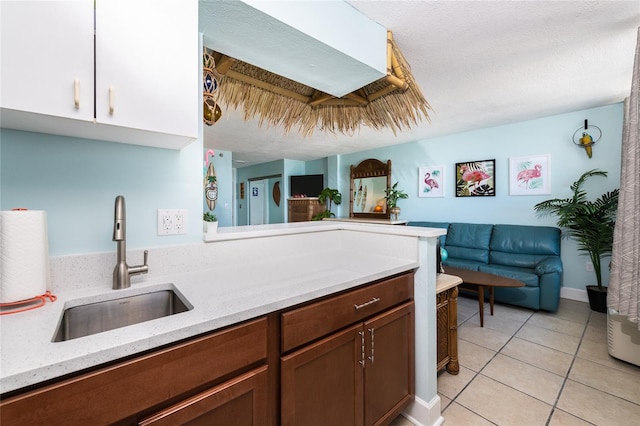 kitchen with sink, light tile patterned flooring, and light stone countertops