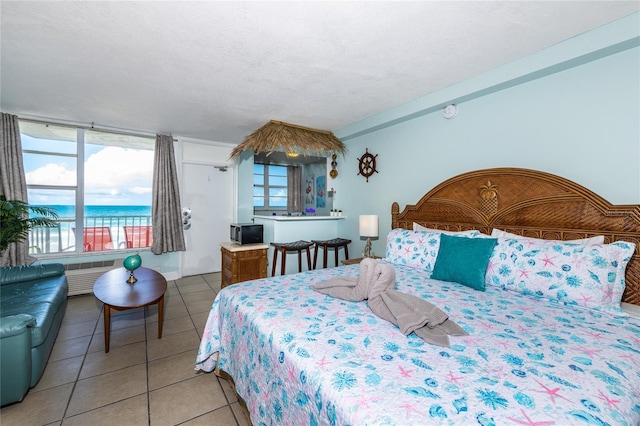 800 N Atlantic Ave Unit 301, Daytona Beach, FL 32118 - bedroom featuring light tile patterned flooring, access to outside, and a water view