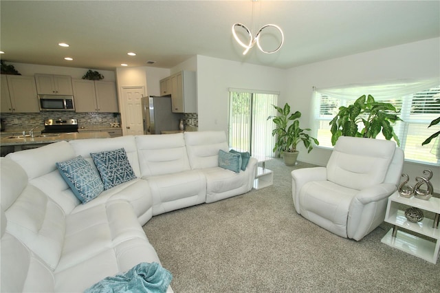 carpeted living room featuring a chandelier and sink