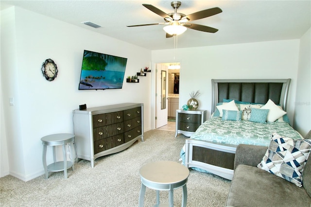 bedroom featuring ceiling fan, ensuite bathroom, and light carpet