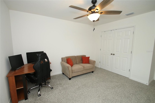 carpeted home office featuring ceiling fan