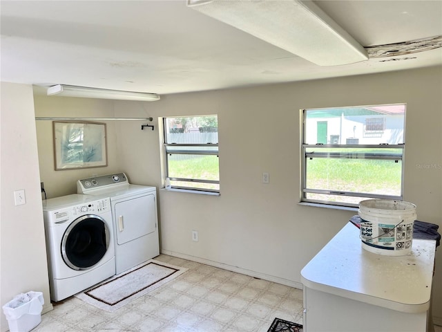 laundry area featuring a wealth of natural light, washing machine and dryer, and light tile patterned floors