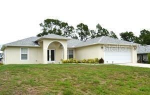 ranch-style home with a garage and a front lawn