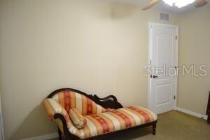 sitting room with carpet and ceiling fan