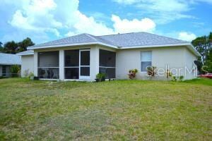 back of house featuring a sunroom and a yard