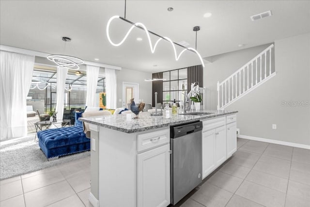 kitchen featuring light tile patterned floors, white cabinetry, open floor plan, dishwasher, and a center island with sink