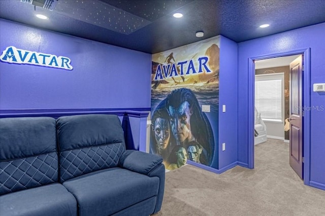 home theater room featuring carpet floors and a textured ceiling