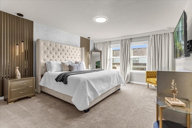 bedroom featuring light carpet, a textured ceiling, and baseboards