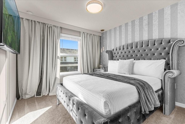 bedroom featuring baseboards, carpet, and wallpapered walls