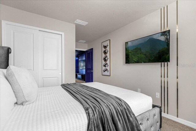 carpeted bedroom with a closet, visible vents, and baseboards